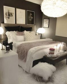 a white bed sitting in a bedroom next to two lamps and pictures on the wall