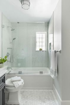 a bathroom with a toilet, sink and bathtub next to a window in it