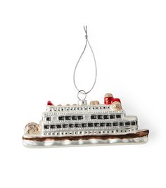 a christmas ornament with a cruise ship on it's side and ornaments hanging from the front