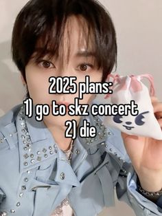 a man in blue shirt holding up a white object with the words 205 plans 1 go to sky concert 2 die