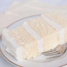 a piece of white cake on a plate with a fork and napkin next to it