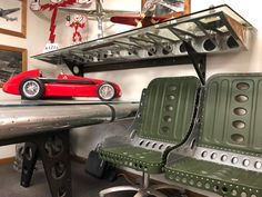 a green chair sitting next to a metal table with a red toy car on it