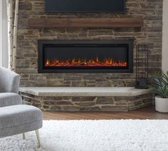 a living room with a large stone fireplace and white rugs on the hardwood floor