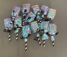 there are many candy bags with black and white striped straws on top of them