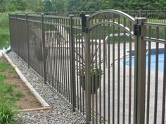 a fenced in swimming pool next to a lush green field