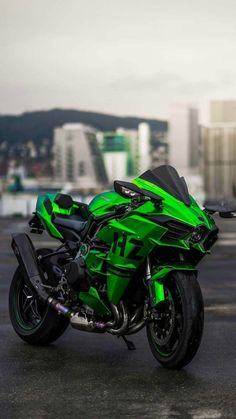 a green motorcycle parked on top of a parking lot