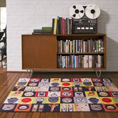 a room with a book shelf and a rug on the floor in front of it