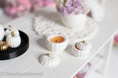 some white pumpkins and candles on a table