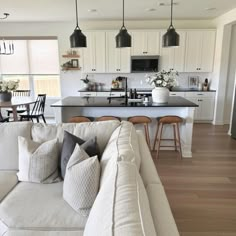 a living room filled with furniture next to a kitchen