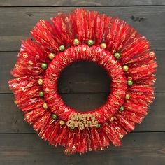 a red christmas wreath on a wooden wall