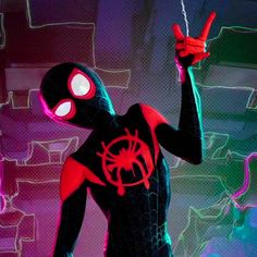 a spider - man standing in front of a wall with neon lights and pointing to the side