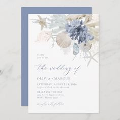 an elegant wedding card with blue flowers and seashells on the front, in white