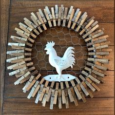 a rooster made out of wooden blocks on top of a wood floor next to a chicken wire fence