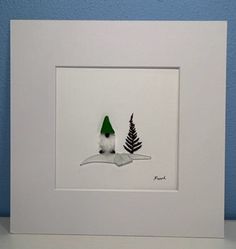 a white frame with a green hat on top of it next to a blue wall