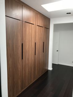 an empty room with wooden cabinets and hard wood floors