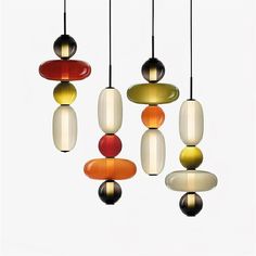 multi - colored glass pendants hanging from the ceiling in an art deco style, against a white background