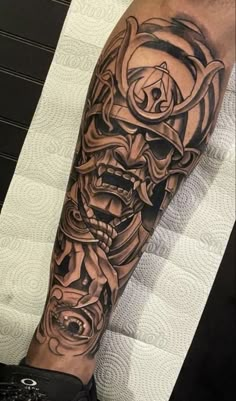 a man's arm with a skull and rose tattoo on the left side of his arm