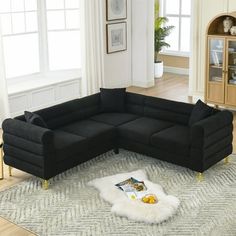 a black sectional sofa sitting on top of a white rug