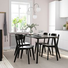 a dining table and chairs in a room with pink walls