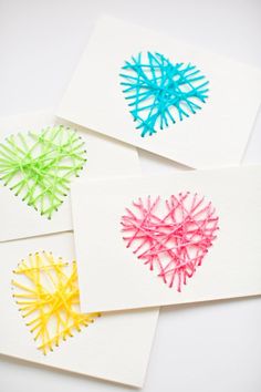 four handmade cards with different colored yarns in the shape of hearts on them