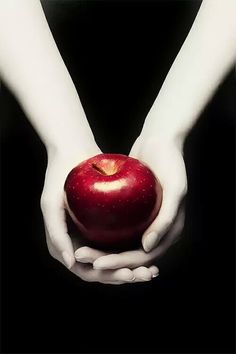 a person holding an apple in their hands