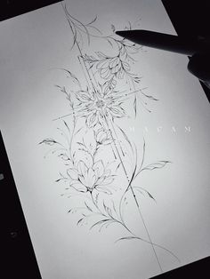 a drawing of some flowers on a piece of paper with a pen next to it