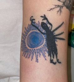 a tattoo on the arm of a person with an insect and sun in the background