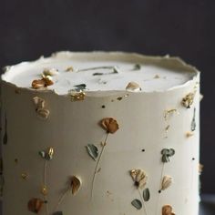 a close up of a cake with flowers on it and frosting around the edges