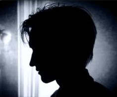 the silhouette of a person in front of a door