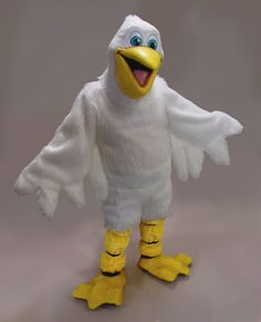 a white and yellow stuffed bird with big blue eyes on it's head, standing in front of a gray background