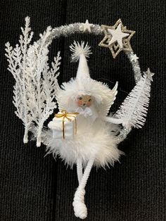 a white christmas ornament hanging on a black background with stars and snowflakes