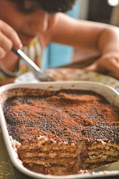 a child is eating food from a dish