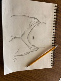 a pencil drawing of a woman's breast on paper next to a yellow pencil