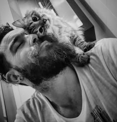 a man holding a cat up to his face