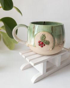 a ceramic mug sitting on top of a wooden stand