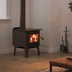 a wood burning stove in the corner of a room with no one around it,