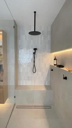 a bathroom with white walls and flooring has a glass shower door that opens up to the bathtub