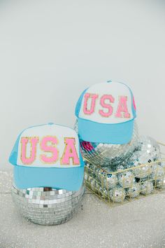 Complete your kid's wardrobe with this stylish and fun Mini Kids Pink USA Trucker Hat. Featuring classic pink letters USA with a white and blue trucker, this hat is perfect for expressing your patriotic spirit in a fashionable way. Guaranteed to be a hit! All orders are currently shipping within 14 business days. To receive item quicker, expedited shipping is available at checkout. Adjustable Blue Trucker Hat For 4th Of July, Patriotic Blue Trucker Hat For 4th Of July, Trendy Cap For 4th Of July, Spring Blue Trucker Hat With Letter Print, Playful Trucker Hat With Letter Print, Playful Letter Print Trucker Hat, Playful Trucker Hat With Graphic, Fun Blue Trucker Hat With Letter Print, Trucker Hat Designs