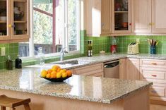 a bowl of oranges sitting on top of a kitchen counter