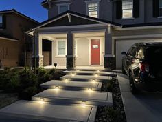 a car parked in front of a house with steps lit up to the door and windows