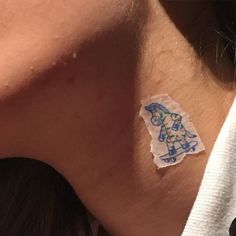 a close up of a person's neck with a piece of sticker on it