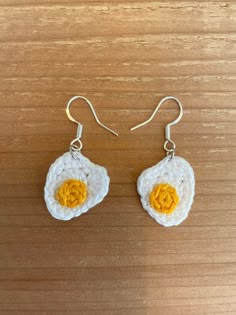 the earrings are made up of white and yellow crochet