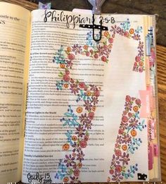 an open bible with colorful flowers on it