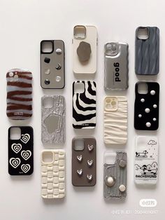 there are many cell phones lined up on the white surface, each with different designs