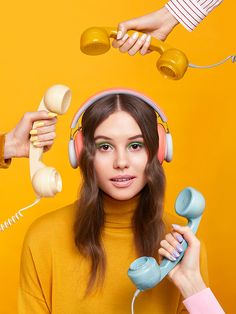 a woman wearing headphones and holding two telephones