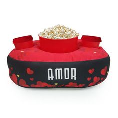 a red and black dog bed with popcorn in it that says amo on the front