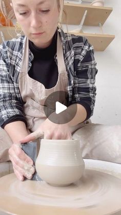 a woman is making a pot on a pottery wheel