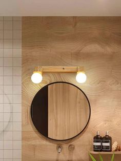 a bathroom with a sink, mirror and light fixture on the wall next to it