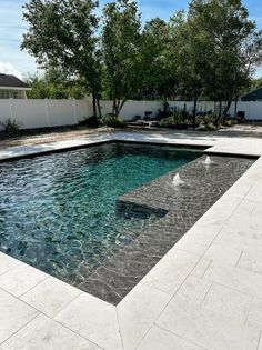 an empty pool in the middle of a backyard with water running through it and trees