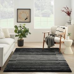 a living room filled with furniture and a potted plant in the middle of the room